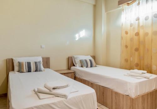 two beds in a room with towels on them at Fontana Luxury Rooms in Mytilini