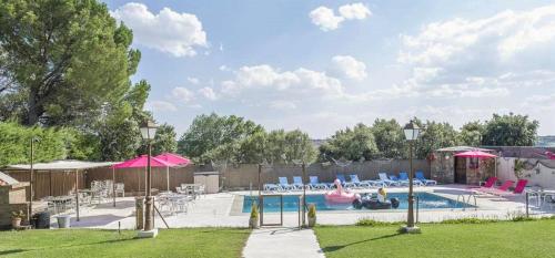 a swimming pool with chairs and umbrellas in a yard at Abantos LA CASA DE GALAPAGAR in Galapagar