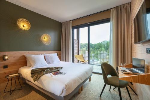 Cette chambre comprend un lit et une grande fenêtre. dans l'établissement Hôtel le Bout du Parc, à Versailles