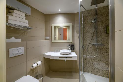 a bathroom with a shower and a toilet and a sink at Best Western Plus Ajaccio Amirauté in Ajaccio