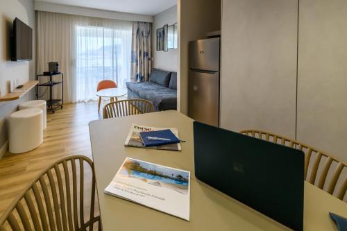 a kitchen and living room with a table and chairs at Best Western Plus Ajaccio Amirauté in Ajaccio