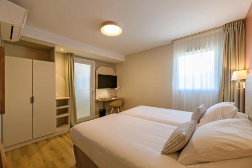 a hotel room with a bed and a desk at Best Western Plus Ajaccio Amirauté in Ajaccio