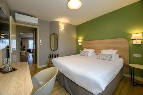 a bedroom with a large white bed and a table at Best Western Plus Ajaccio Amirauté in Ajaccio