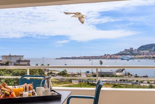 a bird flying over a table with a tray of food at Best Western Plus Ajaccio Amirauté in Ajaccio