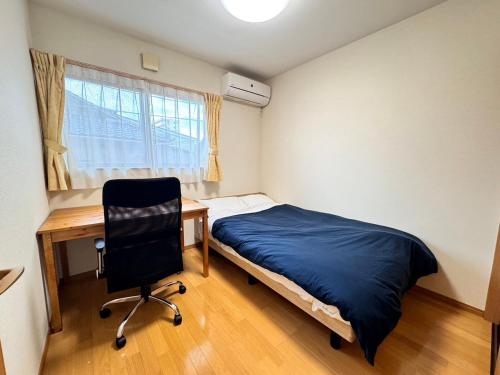 a bedroom with a desk and a bed and a chair at tomari in Okayama