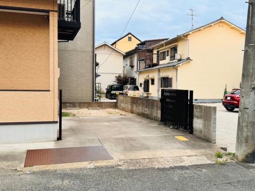 a parking lot with houses and a fence at tomari in Okayama