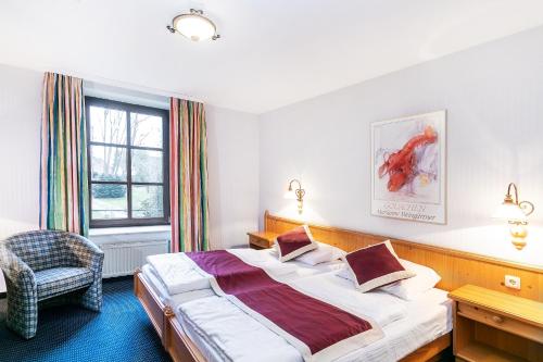 1 dormitorio con 1 cama grande y 1 silla en Landhaus Danielshof, en Bedburg