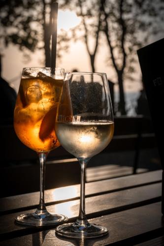two glasses of white wine sitting on a table at Hotel Anna Villa in Balatonföldvár