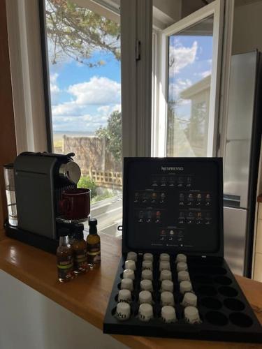 un ordinateur portable assis sur un comptoir à côté d'une fenêtre dans l'établissement Maison familiale-Vue sur la mer, à La Plaine-sur-Mer