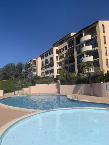 une piscine vide en face d'un bâtiment dans l'établissement Appartement Domaine de la Coudouliere dont piscine de mai à septembre, à Six-Fours-les-Plages