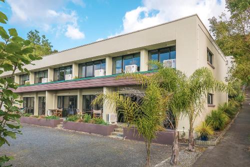 a white building with plants in front of it at Paihia Pacific Resort Hotel in Paihia