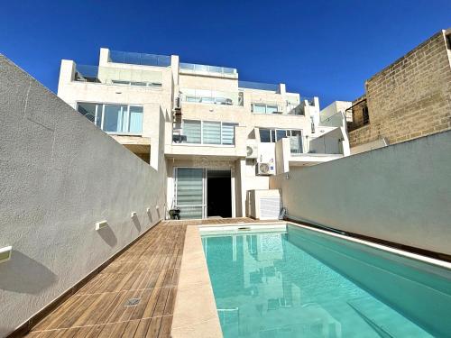 una casa con piscina delante de un edificio en All Nations Duplex with Pool, en Xagħra