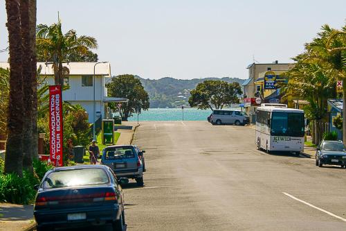 a street with cars and a bus driving down a road at Paihia Pacific Resort Hotel in Paihia