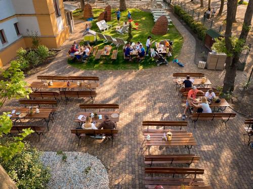 a group of people sitting on benches in a park at Hotel Anna Villa in Balatonföldvár