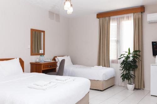 pokój hotelowy z 2 łóżkami i oknem w obiekcie Homelike Guest House w mieście Kirenia