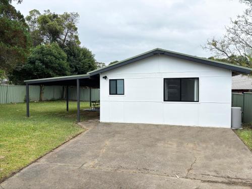 a house with a white garage at Bowerbird Cottage in Camberwarra