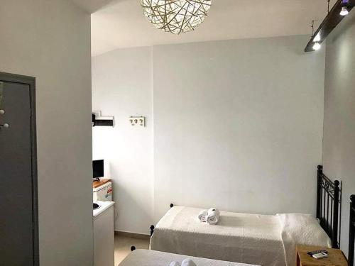 a bedroom with two beds and a chandelier at Oikeion in Ermoupoli