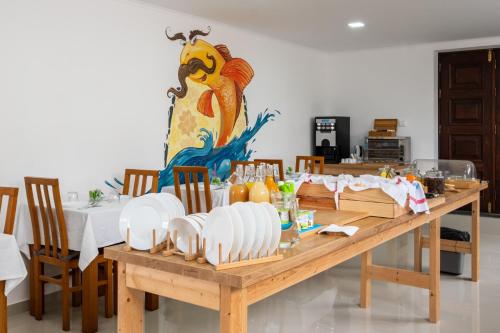 a wooden table with plates on top of it at West Side Guesthouse in Peniche