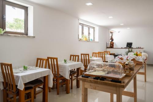a dining room with white tables and chairs and windows at West Side Guesthouse in Peniche