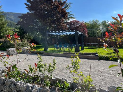 cenador con sillas y mesa en el jardín en La maison Valban, en Veynes
