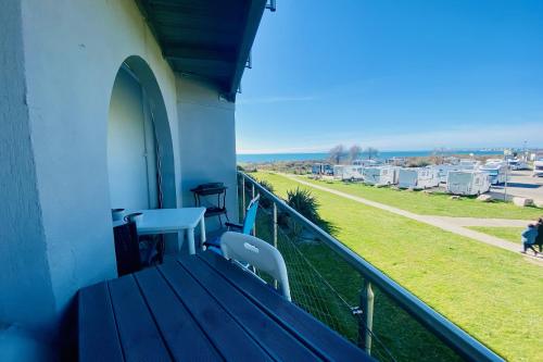 balkon ze stołem i krzesłami oraz widokiem w obiekcie A101 L'écume des Vagues w mieście Le Grau-du-Roi