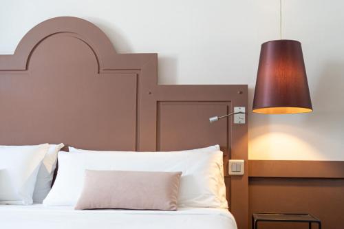 a bedroom with a bed with a large headboard and a lamp at La Maison des Armateurs in Saint Malo
