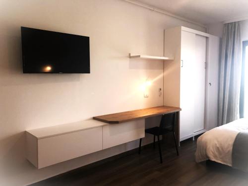 a bedroom with a desk with a tv on the wall at Mamaia SUNNY LOFT in Mamaia