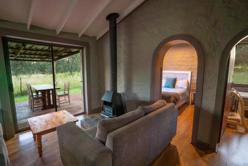 a living room with a couch and a bedroom at Kokopelli farm in Magaliesburg