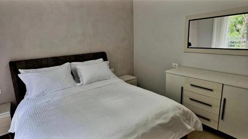 a bedroom with a white bed and a window at Hotel DEMOLI in Pogradec