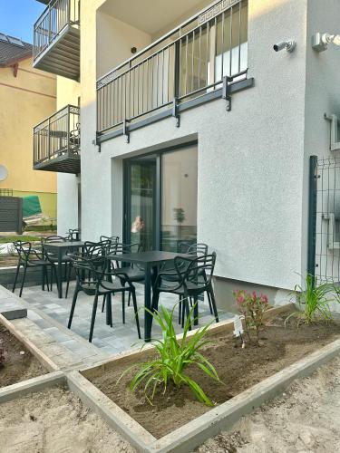 a patio with black tables and chairs in front of a building at Pokoje Dziwnów Welle in Dziwnów