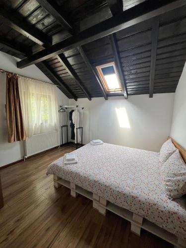 a bedroom with a bed in a room with wooden floors at Pensiunea Roxana in Buzău