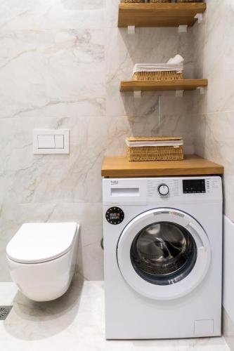 a bathroom with a washing machine and a toilet at Nikos Studios in Keri
