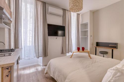 a bedroom with a bed with a television and a desk at Short Time Suites Toulon Centre 2 " LE COSY" Check-in auto in Toulon
