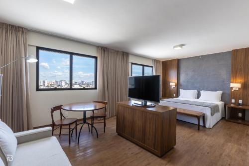 a hotel room with a bed and a flat screen tv at Gran Executive Hotel in Uberlândia