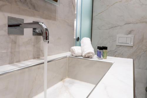 a shower with a faucet and a sink in a bathroom at Nikos Studios in Keri