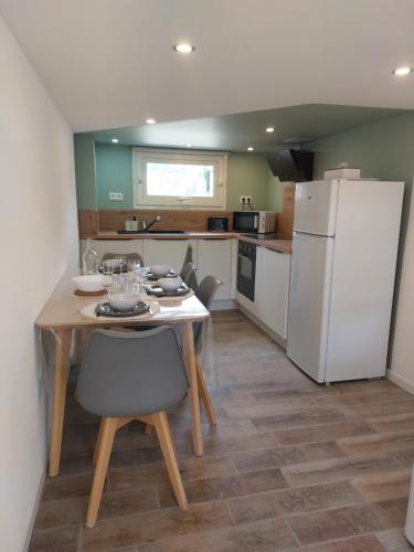 a kitchen with a table and a white refrigerator at Le Studio de L'Ayguade - Plage à 100 m in Hyères