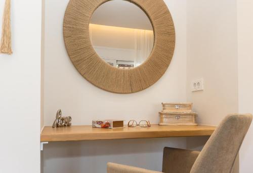 a mirror on a wall above a wooden table at Nikos Studios in Keri