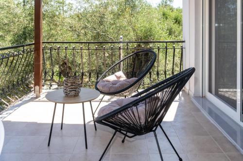 a patio with two chairs and a table on a balcony at Nikos Studios in Keri