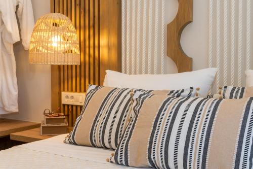 a bedroom with a bed with a pillow and a chandelier at Nikos Studios in Keri
