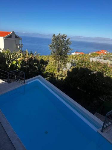 a swimming pool with a view of the ocean at VILLA FELICIDADE in Arco da Calheta