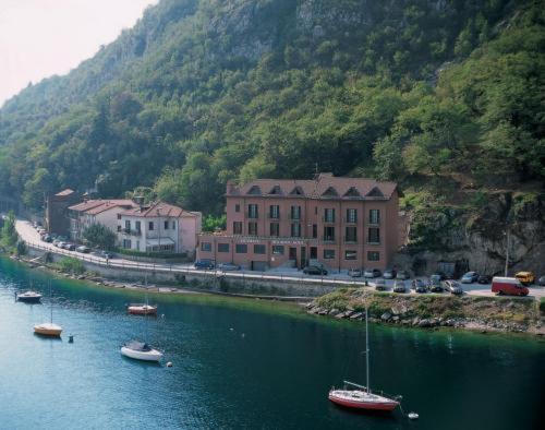 a group of boats in the water next to a mountain at Hotel Bellavista in Valmadrera