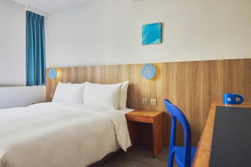 a hotel room with a large bed and a desk at The Blue by Just Inn in Taipei