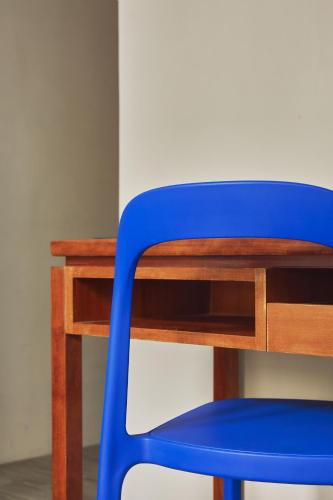 a blue chair sitting next to a wooden desk at The Blue by Just Inn in Taipei