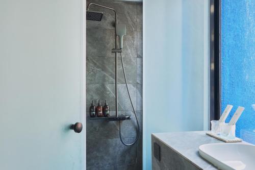 a bathroom with a shower and a sink at The Blue by Just Inn in Taipei