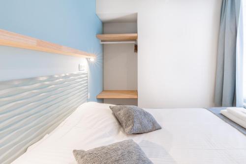 a bedroom with a white bed and a window at Hotel José in Blankenberge