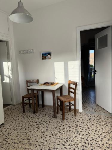 a table and chairs in a white room with a table and chairs at Akti Rooms And Studios in Livadion