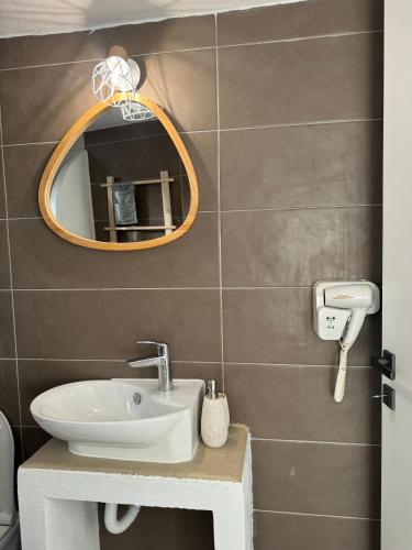 a bathroom with a sink and a mirror at Akti Rooms And Studios in Livadion