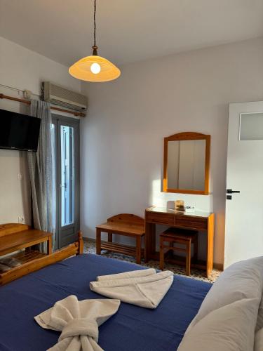 a bedroom with a bed and a desk and a mirror at Akti Rooms And Studios in Livadion