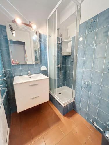 une salle de bain carrelée bleue avec un lavabo et une douche dans l'établissement 3369-Appartement 4 couchages avec piscine, tennis, à Argelès-sur-Mer