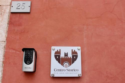 a sign on the side of a red wall at Centro storico Bed and Breakfast in Vico del Gargano